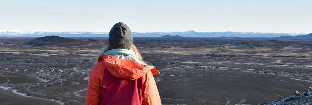 woman overlooking black sand