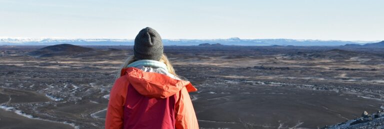 woman overlooking black sand
