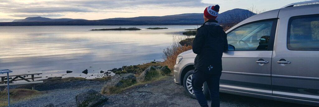 Man next to campervan looking at ocean