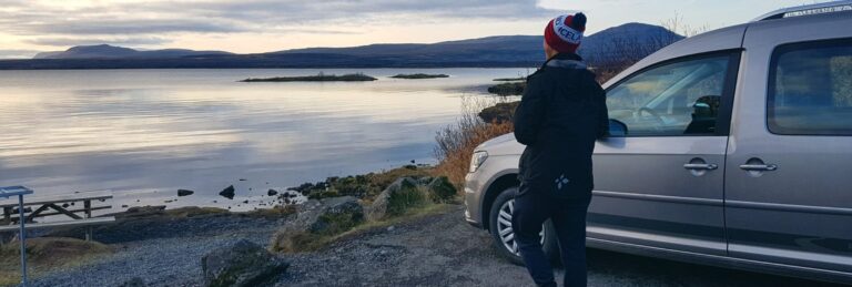 Man next to campervan looking at ocean