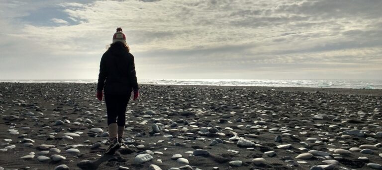 Woman walking at a black sand beach