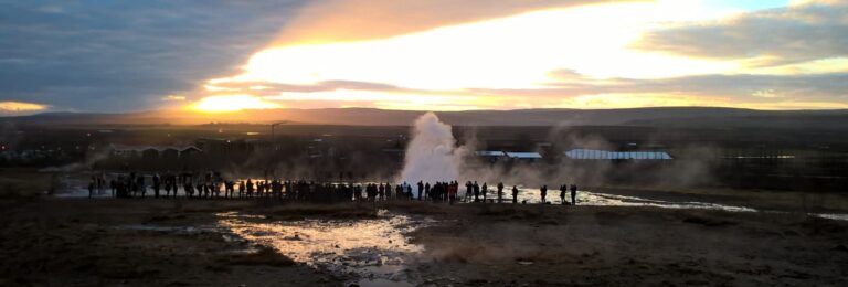 Group of tourist standing and lookig at the geyser