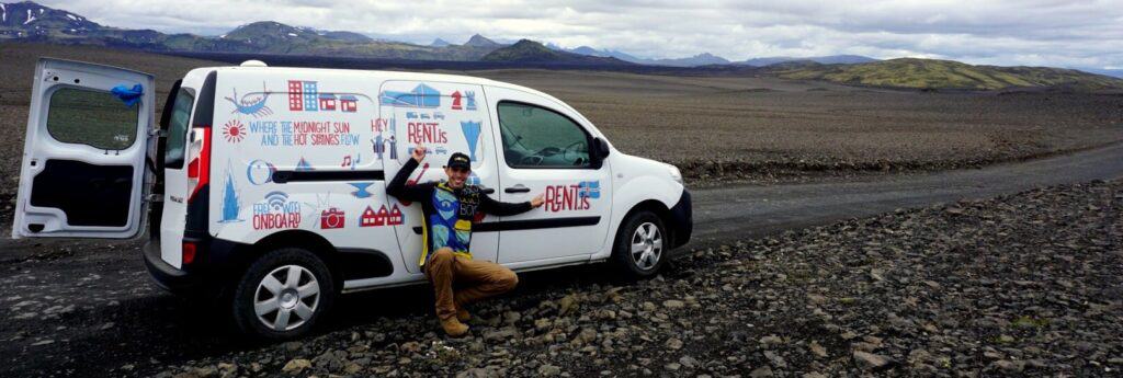 Man sitting in front of rent.is camper van