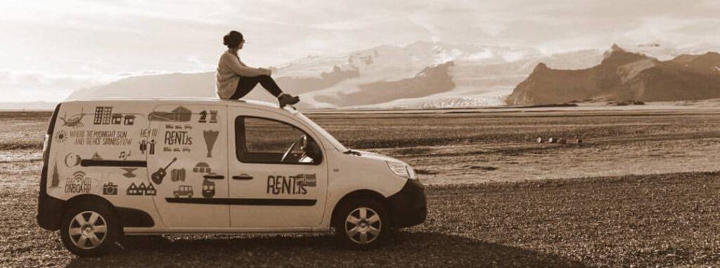 Woman sitting on top of a rent.is camper van