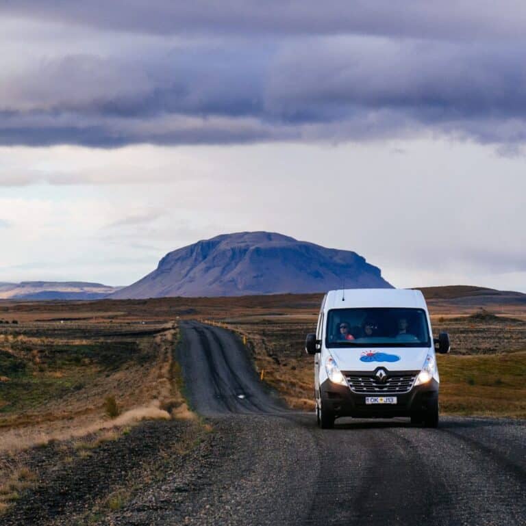 rent.si camper van drivin on road with mountain