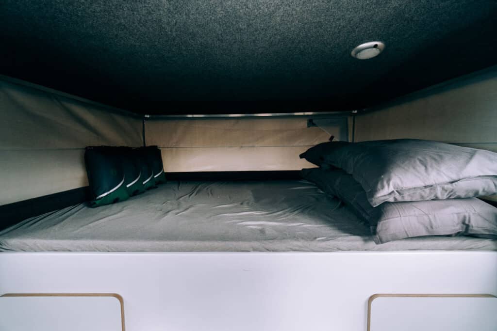 Toyota Hilux 4×4 Camper interior sleeping area, pillows, sleeping bags