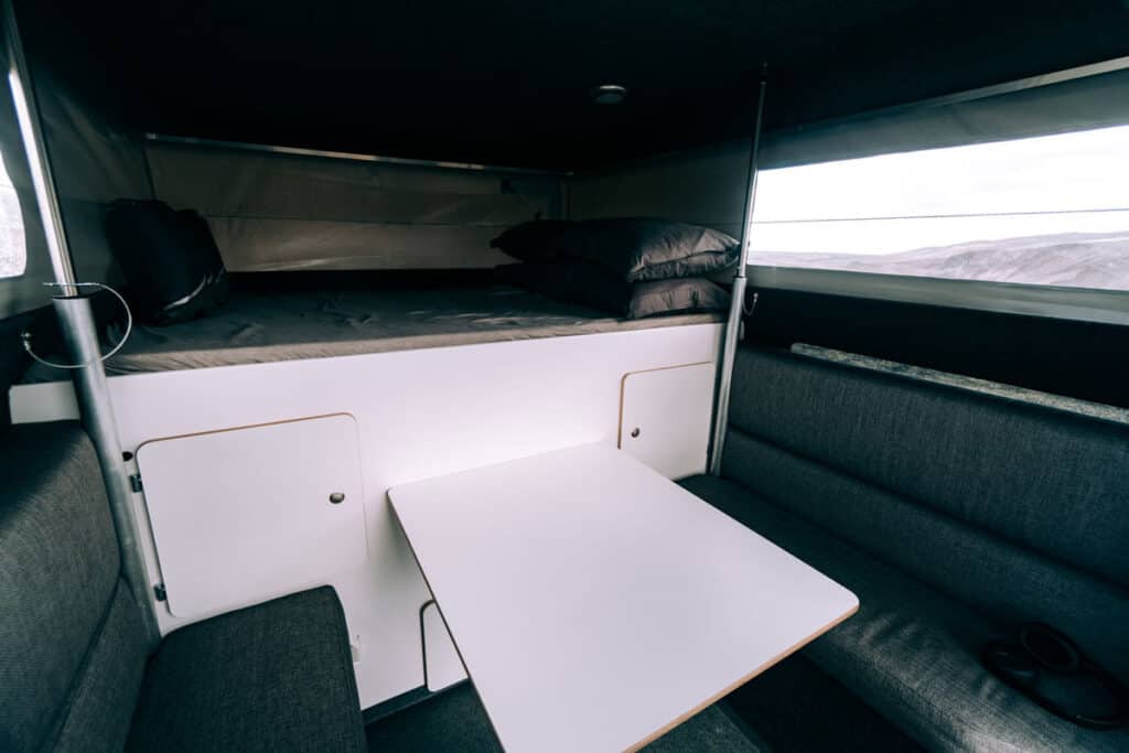 Toyota Hilux 4×4 Camper interior sleeping area, table, chairs