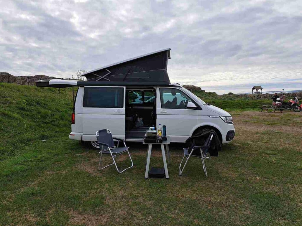 The VW California set up at a campsite ready for sleep and dinner.