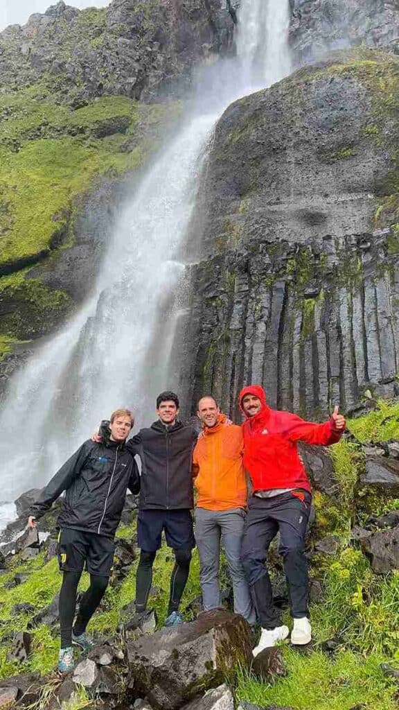 Four guys posing by a waterfall