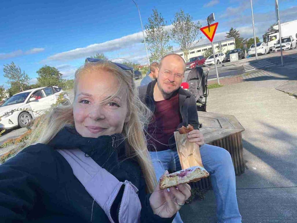 A couple sitting and eating cinnamon buns