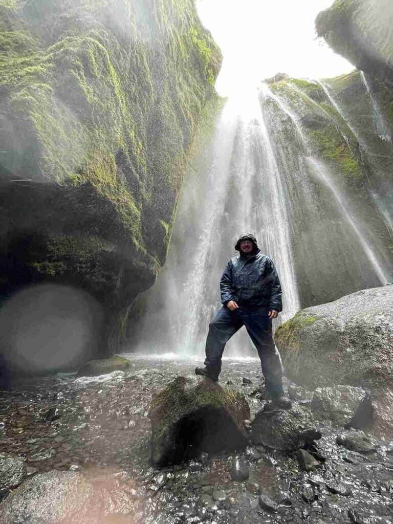 A man standing by Gljúfrabúi waterfall