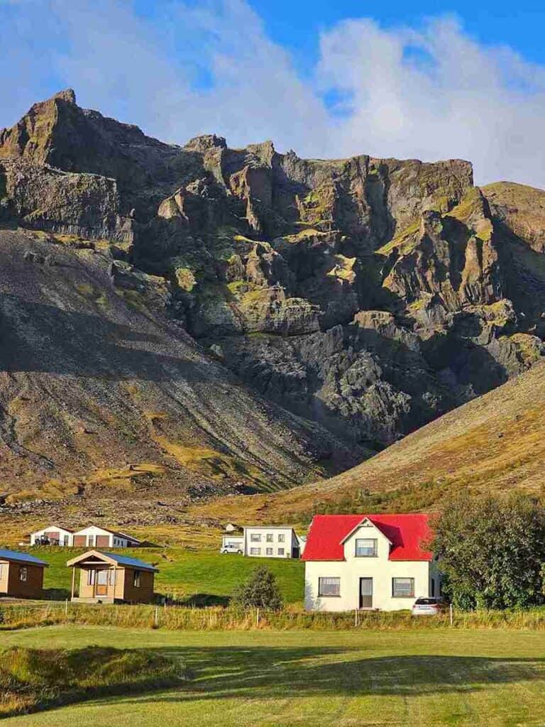 A valley by a mountain, with old houses and grass