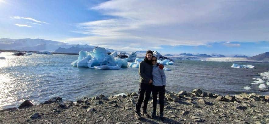 A couple standing by the glacier lagoon