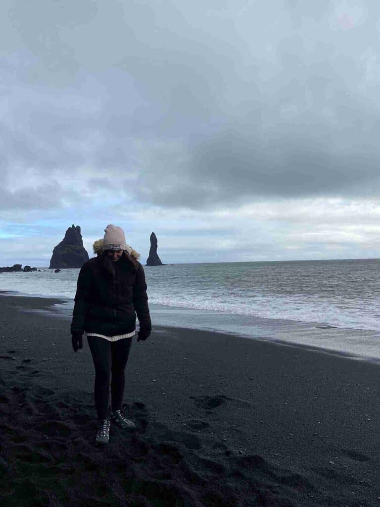 A woman walking on the black beach