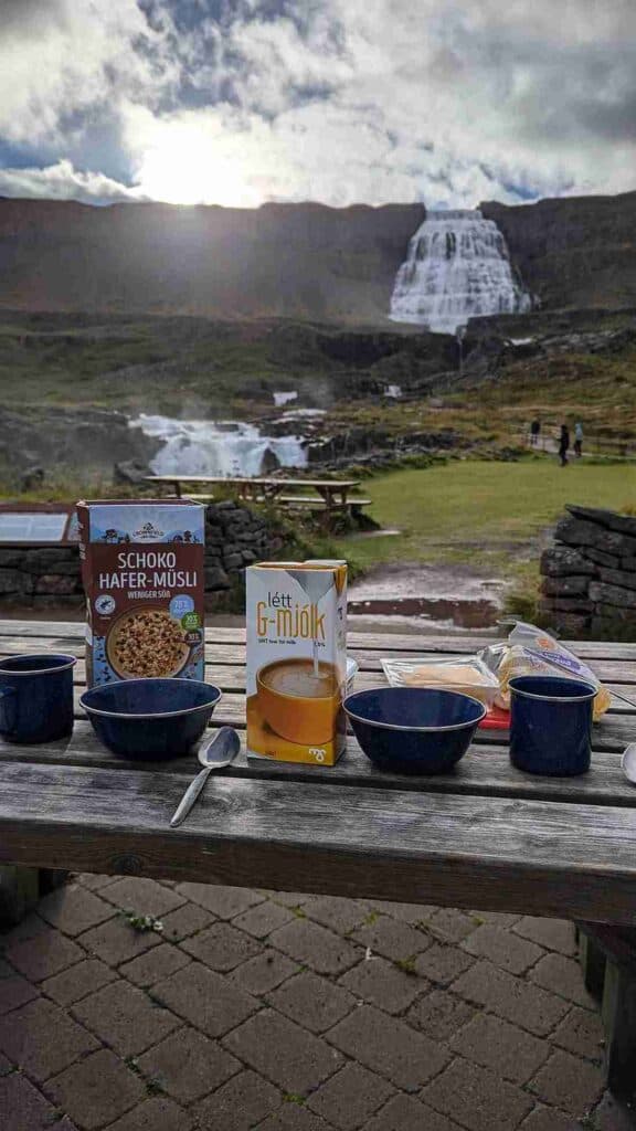 Breakfast on a camping table by a waterfall