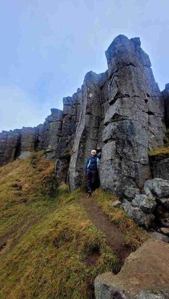 A woman standing by a rock formation