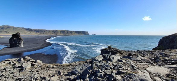 The ocean waves by a black beach coast
