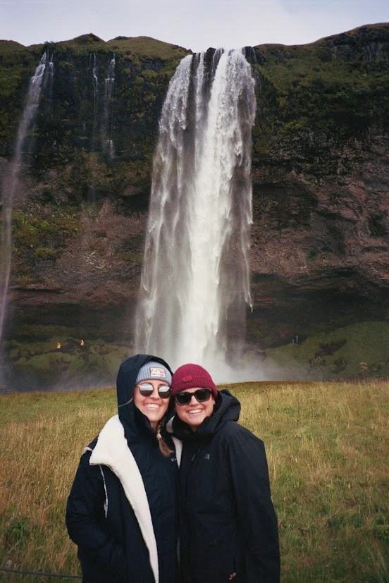 Two girls posing by a waterfall