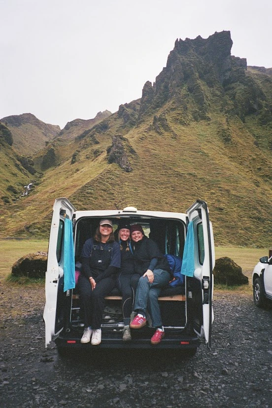 Three girls sitting in the back of a van