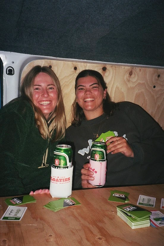 Two women sitting in camper and playing cards