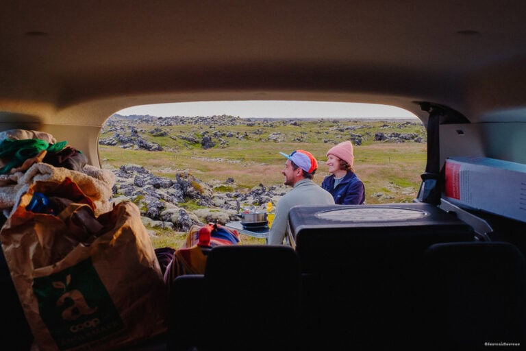 Two people eating at the back of a camper