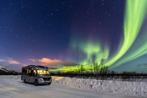 Camper van parked under the Northern Lights in Iceland, illustrating one of the most fascinating facts about Iceland.
